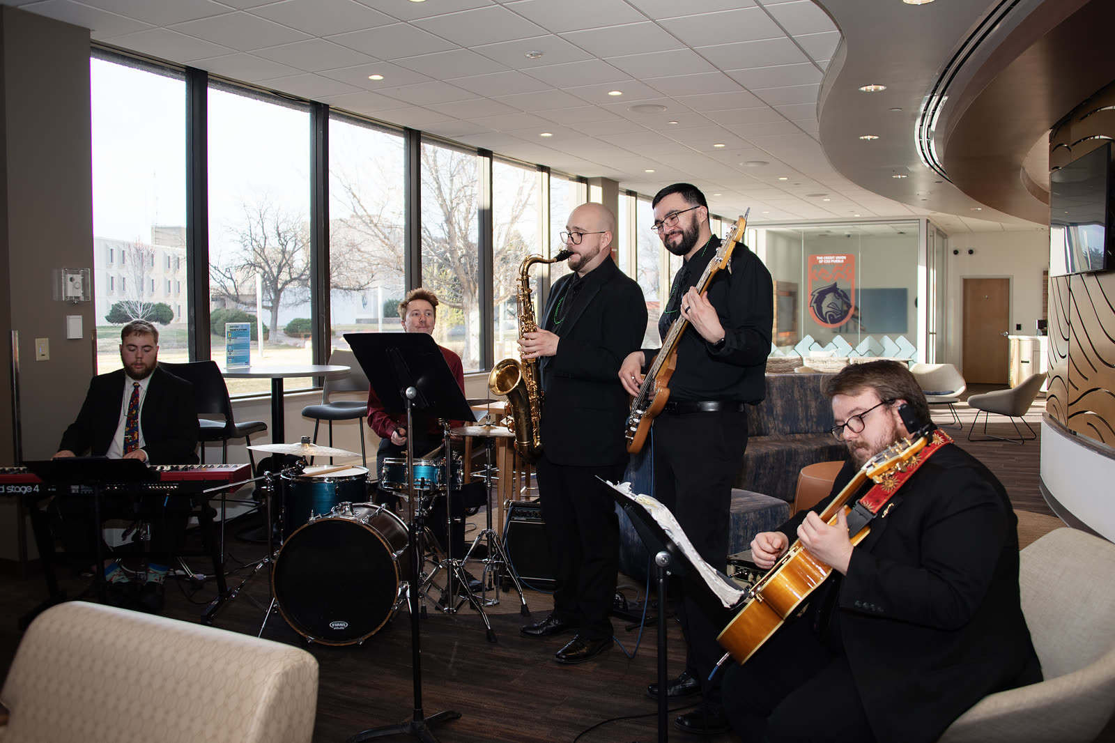 Full 5 O'Clock Five ensemble performing in a bright event space
