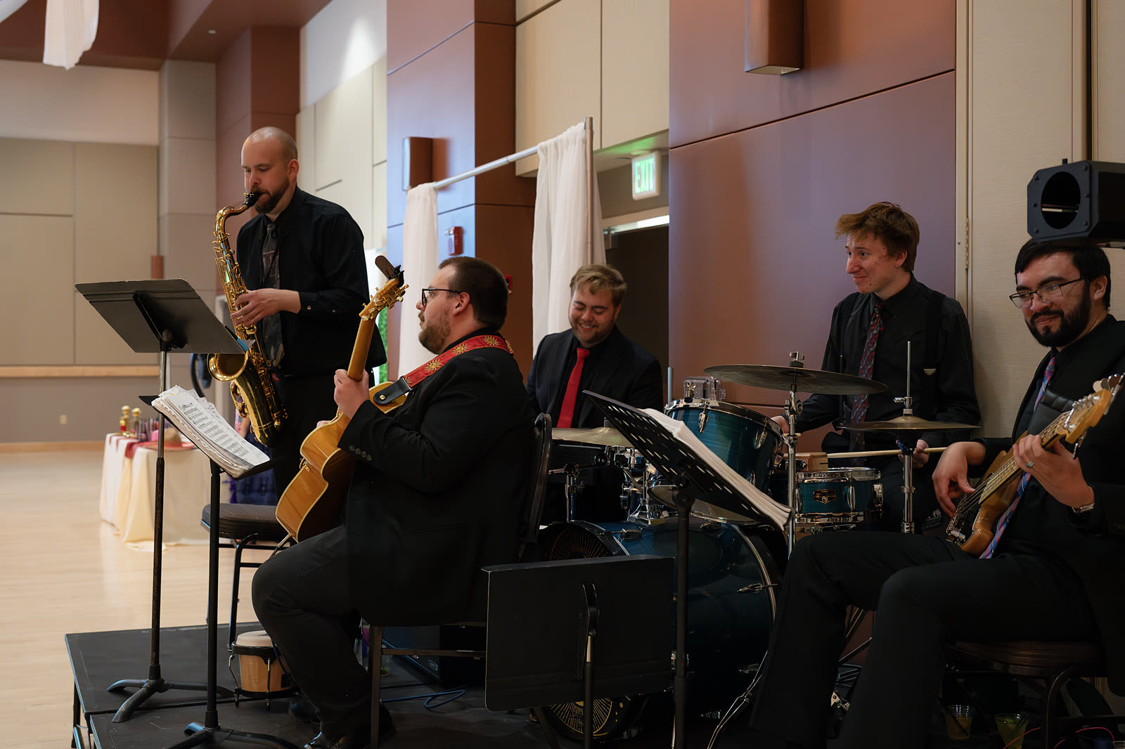 5 O'Clock Five performing together in a reception hall